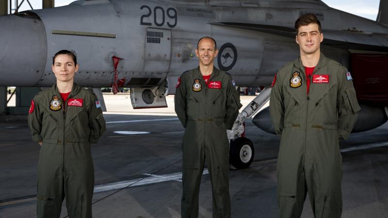 New RAAF Super Hornet graduates Pilot Officer Elysia Cave-Freeman (left) and Pilot Officer Jack Leavesley (right) with Squadron Leader Glyn Williams, No. 82 Wing instructor, at RAAF Base Amberley. Photo: Leading Aircraftwoman Emma Schwenke. 