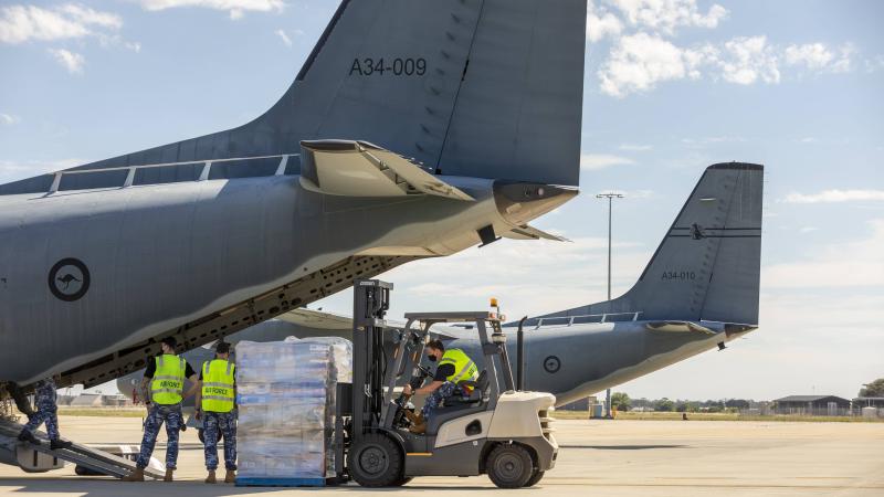 Air Force Aviators load supplies onto a C-27J Spartan aircraft tasked to fly to isolated Coober Pedy, South Australia. Photo:  Leading Aircraftman Stewart Gould