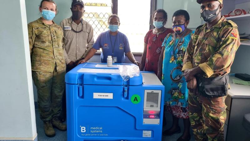 Australian Army officer Captain Jyra Blake-Waller, left, and PNGDF officer Captain Charles Namuesh, right, deliver a solar-powered vaccination fridge to Mumeng Health Centre, Morobe Province, PNG. Photo: Captain Nathanael Kennedy.