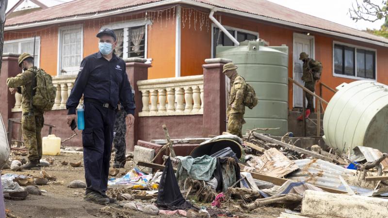 ADF and Department of Foreign Affairs & Trade crisis response team personnel assess the damage on Atata island, Tonga. Photo: Corporal Robert Whitmore.