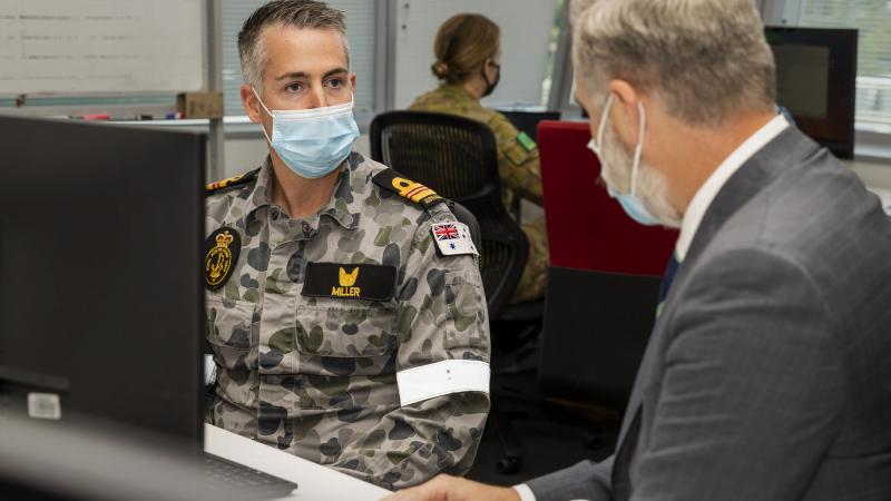 Navy planning officer Lieutenant Commander Tom Miller talks with Mr Glen Bradley from the Department of Health's Aged Care Taskforce in Canberra. Photo: Corporal Julia Whitwell.