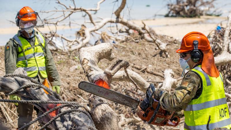 Australian Army soldier Lance Corporal Kobie Rogers, right, and Republic of Fiji Military Forces engineer Sapper Ilimotama Bulusui cut a downed tree on Atata Island, Tonga. Photo: Corporal Robert Whitmore