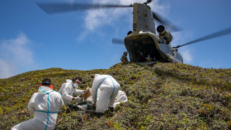 An Army CH-47F Chinook helicopter lands on Kao Island, allowing three Tongan technicians to unload equipment to repair telecommunications equipment. Photo: Petty Officer Christopher Szumlanski.
