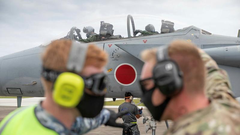 RAAF aviator Leading Aircraftman Ronan Geoghgan, left, and a USAF airman prepare to refuel a Japanese F-15J Eagle aircraft using a USAF refuelling vehicle. Photo: Leading Aircraftman Sam Price