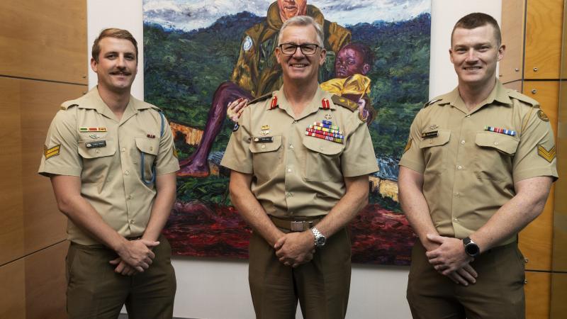   Chief of Army Lieutenant General Rick Burr with Corporal Quinn Jensen, left, and Corporal Taylor Cameron in front of a painting of Trooper Jonathon Church at Army Headquarters in Canberra. Photo: Corporal Sagi Biderman