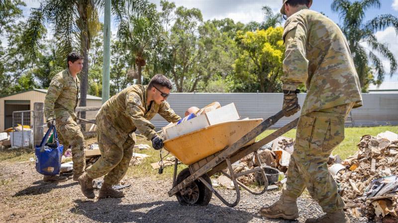 Army soldiers Corporal Joel Down, left, Private Aaron Smith, centre, and Private Zach Quick from 6th Battalion, Royal Australian Regiment, assist Gympie residents clean up. Photo: Corporal Jonathan Goedhart