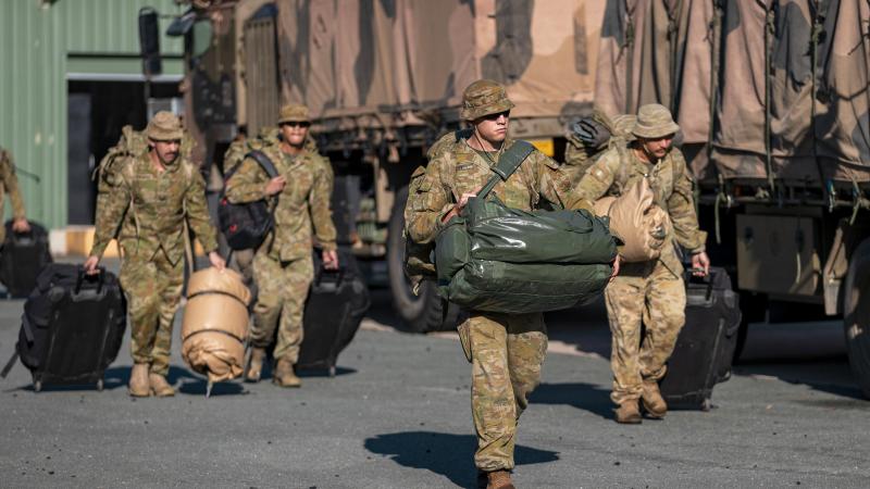 Army officer Lieutenant Thomas West, front, and other soldiers load gear onto trucks at Gallipoli Barracks in Brisbane in preparation to deploying to Gympie as part of Operation Flood Assist 2022. Photo: Corporal Nicole Dorrett