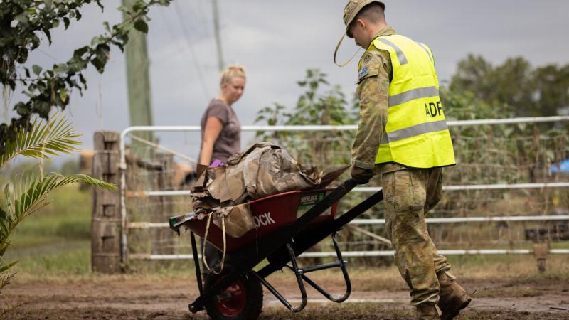 An Australian Army soldier from the 2nd / 14th Light Horse Regiment (Queensland Mounted Infantry), clears flood damage debris from houses in Gatton, Queensland. Photo: Corporal Jonathan Goedhart.