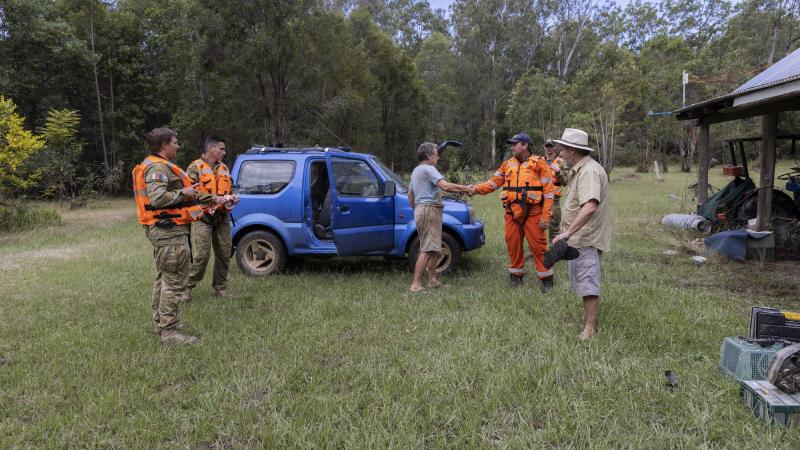 Coraki SES commander Daniel Clark, centre right, and Australian Army soldiers check on Bungawalbin Creek locals in northern New South Wales as part of Operation Flood Assist 2022. Photo: Corporal Sagi Biderman