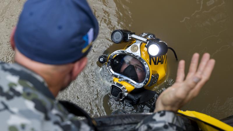 Royal Australian Navy clearance diver Able Seaman Jake Phillips prepares to survey ferry terminal pylons along the Brisbane River as part of Operation Flood Assist 2022. Photo: Corporal Julia Whitwell