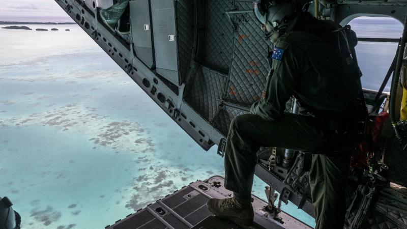 Royal Australian Air Force loadmaster Corporal Jakeb Thorogood watches for fishing vessels over the C-17J Spartan aircraft ramp during a maritime surveillance flight over Palau as part of Operation Solania. Photo: Leading Seaman Nadav Harel