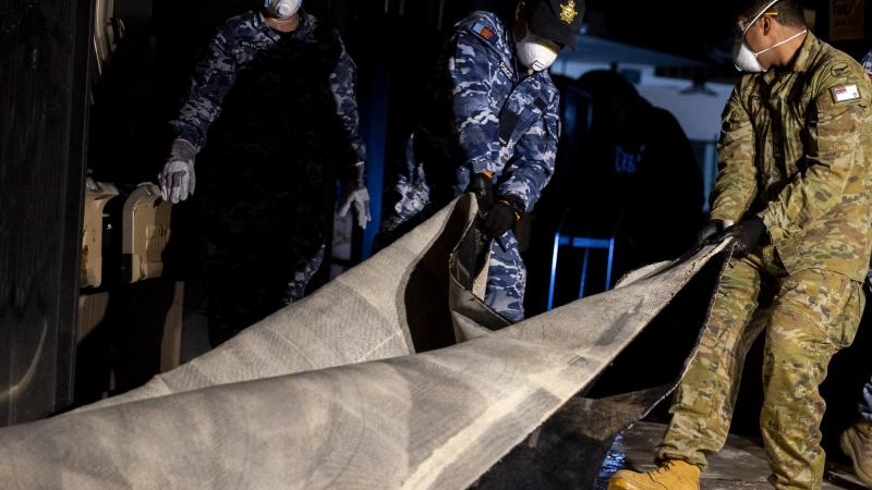 Air Force personnel remove flood-damaged carpet from Goodna Services Club, Brisbane, as part of Operation Flood Assist 2022. Photo: Corporal Julia Whitwell