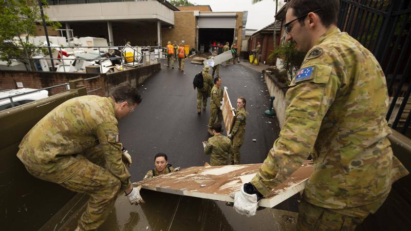 Army soldiers Sapper Callan Stuart, left, and Sapper Ben Lowe, right, load flood-damaged furniture and equipment from Lismore police station in northern NSW onto a truck. Photo: Warrant Officer Class Two Max Bree