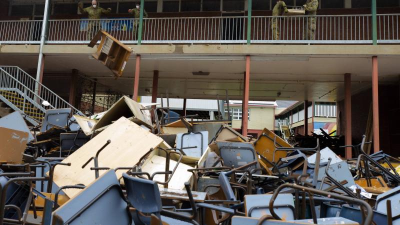Australian Army troopers from 1st Armoured Regiment remove flood-damaged equipment and furniture from Richmond River High School in Lismore, NSW. Photo: Warrant Officer Class Two Max Bree