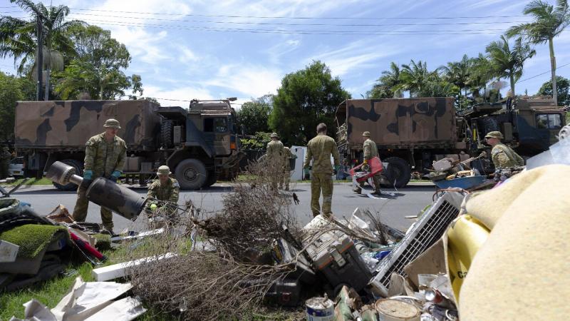 Australian Army soldiers from 6th Battalion, Royal Australian Regiment, clear flood-damaged household items a street in Chinderah, NSW. Photo: Warrant Officer Class Two Max Bree
