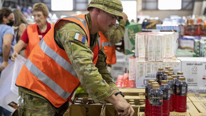 Private Darren Loveday assists volunteers sort essential supplies donated for flood-affected community members at the Lifeline distribution centre in Lismore. Photo: Leading Seaman Kylie Jagiello