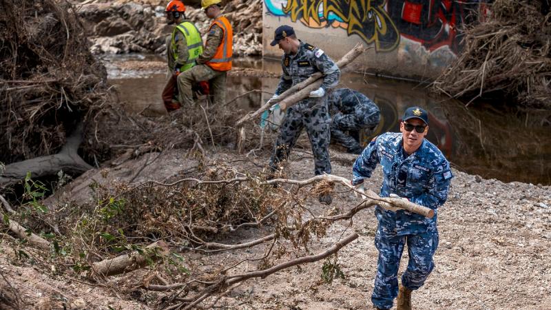 Navy, Army and Air Force personnel clear flood debris from Kedron Brook in Mitchelton, Brisbane, as part of Operation Flood Assist 2022. Photo: Corporal Nicole Dorrett