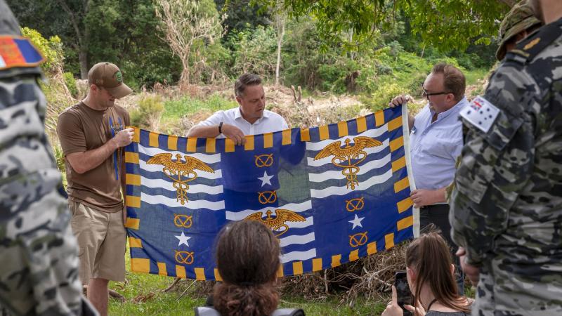 Brisbane Lord Mayor Adrian Schrinner, centre, and Councillor Andrew Wines present Lieutenant Brandon Shellenberger with Brisbane's flag as a token of thanks for the assistance of US personnel during Operation Flood Assist. Photo: Cpl Nicole Dorrett