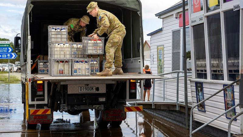 Privates Riva Brown and Jamie Morrison from 41st Battalion, Royal New South Wales Regiment, unload crates of refrigerated milk at Ulmarrra on the NSW northern rivers during Operation Flood Assist 2022. Photo: Corporal Dustin Anderson