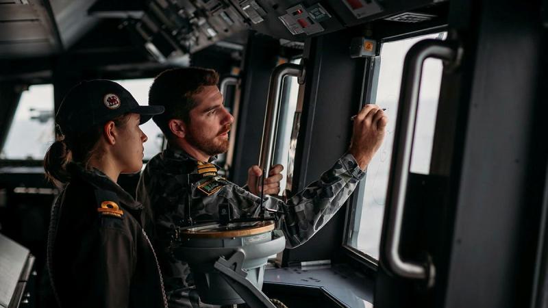 Navigator Lieutenant Dean Gilbert mentors Sub Lieutenant Annabelle Wall as she conducts duties as assistant officer of the watch on the bridge of HMAS Hobart. Photo: Able Seaman Jarryd Capper