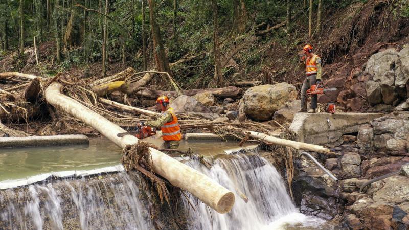Corporal Chris Muelener, left, and Sapper Joe Barns use a chainsaw to clear debris from Mulgum Creek Weir in Nimbin, New South Wales. Photo: Sergeant Nunu Campos