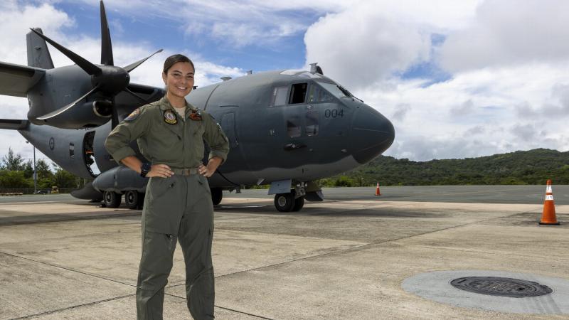 Air Force loadmaster Corporal Antonia Guterres stands on the tarmac in Palau by the C-27J Spartan aircraft she worked on during Operation Solania. Photo: Leading Seaman Nadav Harel