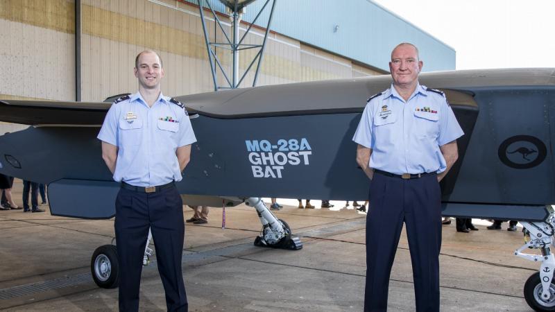 Flight Sergeant Stephan Barchard, right, and Corporal David Grieger stand with the MQ-28A Ghost Bat aircraft at RAAF Base Amberley, Queensland, after winning the Airpower Teaming System naming competition. Photo: Leading Aircraftwoman Emma Schwenke