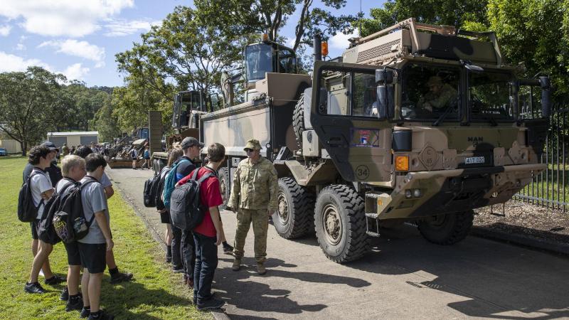 An Australian Army soldier deployed on Operation Flood Assist 2022 talks to Rivers Secondary College students about the Rheinmetall MAN M40 truck during a visit to the school in Lismore, New South Wales. Photo: Leading Seaman Jarrod Mulvihill