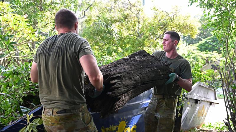 Soldiers from 1st Intelligence Battalion remove a large tree trunk as part of Legacy’s Backyard Assist program in Brisbane.