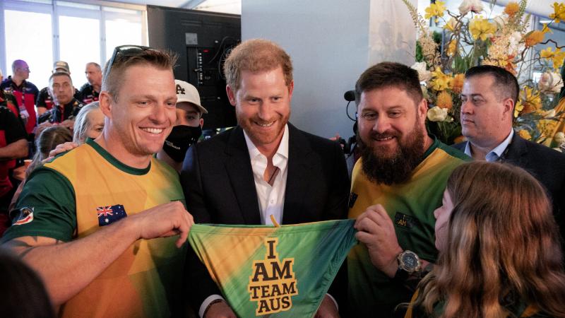 Invictus Games Team Australia competitors Matt Model (left) and Damien Irish (right) gift a pair of Team Australia swimmers to Prince Harry, The Duke of Sussex. Photo: Flight Sergeant Ricky Fuller