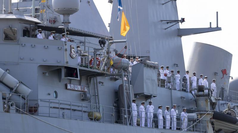 The ship's company of HMAS Arunta line the upper decks as they return to Fleet Base East in Sydney after a three-month regional presence deployment. Photo: Leading Seaman Leo Baumgartner