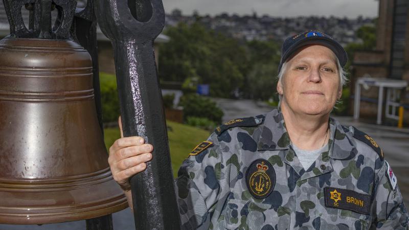 Chief Petty Officer Sharon Brown stands next to the historic HMAS Penguin bell in Sydney. Photo: Able Seaman Benjamin Ricketts