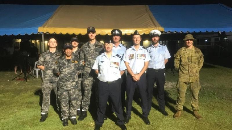 HMAS Glenelg crew members at the Cocos (Keeling) Islands' community Anzac Day dawn service, with Royal Australian Air Force and Australian Federal Police personnel.