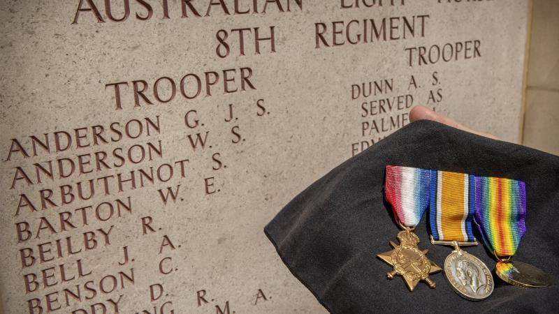 The medals of No. 252 Private Thomas Lowe, of Mitiamo, Victoria, in front of the 8th Light Horse Regiment panel at the Lone Pine Memorial, Gallipoli, on Anzac Day. Photo: Corporal David Cotton