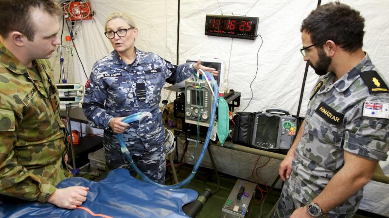 Royal Australian Air Force officer Wing Commander Kylie Hall provides critical care treatment information to Australian Army Captain Ashley St. John and Royal Australian Navy medic Able Seaman Sam Ahmadyar for a series of training scenarios.