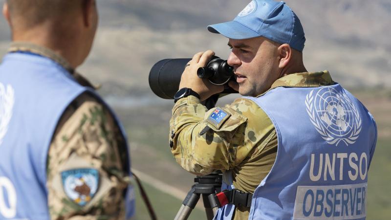 Captain John Whiteley, right, confirms the presence of military equipment with Finnish colleague Captain Pasi Nukarinen during a routine patrol in the Golan Heights. Photo: Petty Officer Lee-Anne Cooper