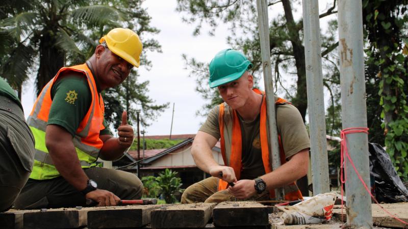 Australian Army soldier Sapper Logan Kocbek, from 2nd Combat Engineer Regiment, and an RFMF engineer secure timber decking during construction of the footbridge. Photo: Corporal Matthew Kenny