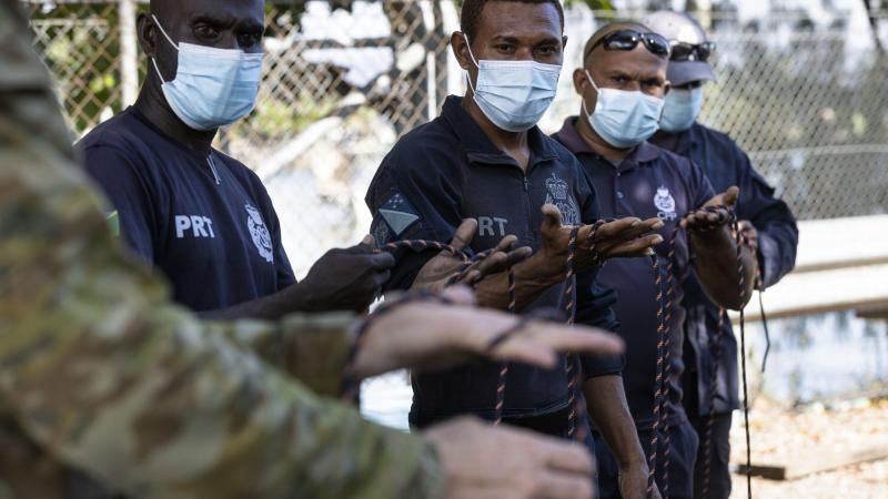 Solomon Islands Police Force officers practise their knot tying skills as part of practical maritime safety training with the Australian Defence Force in the use and maintenance of aluminium long boats in Honiara. Photo: Corporal Julia Whitwell