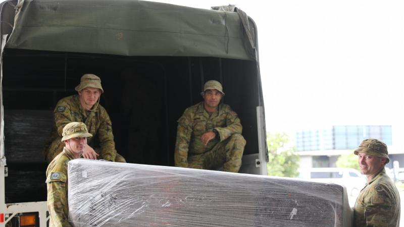 From left, Sergeant Gareth Burrows, Private Rhys McBride, Private Omid Sharifi and Craftsman Ashley Doyle load donated furniture into one of the trucks. Photo: Sergeant Jason Slape