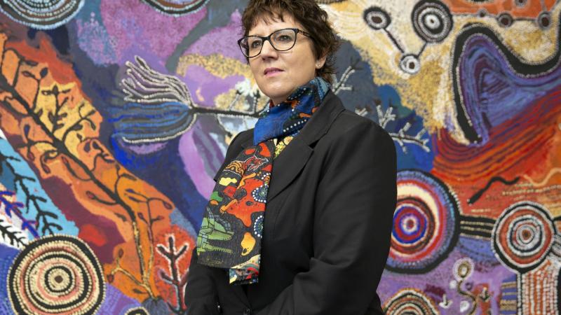 Assistant Director Defence Indigenous Procurement Policy Mrs Tanya Martens from the Capability Acquisition & Sustainment Group stands in front of an Indigenous artwork at Russel Offices in Canberra. Photo: Sergeant Matthew Bickerton 