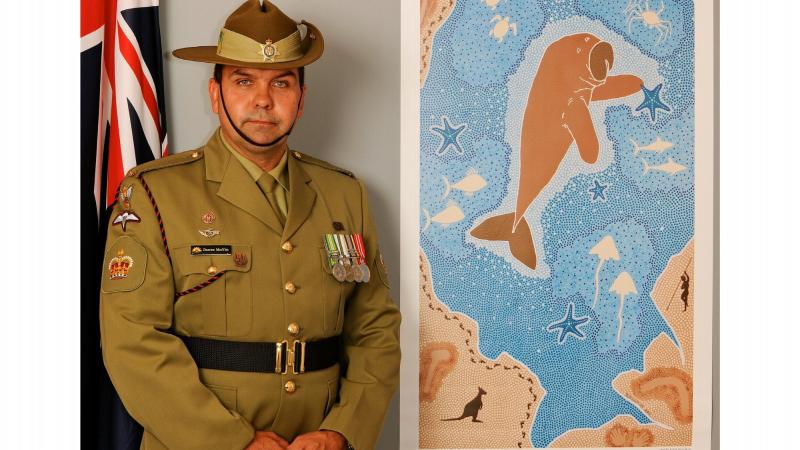 Then Warrant Officer Class 2 Darren Moffitt with his artwork titled “The Salute”.  It depicted a dugong as the centrepiece was created for the Royal Australian Navy’s centenary in 2011.  It told the story of Indigenous service and connection to Navy.