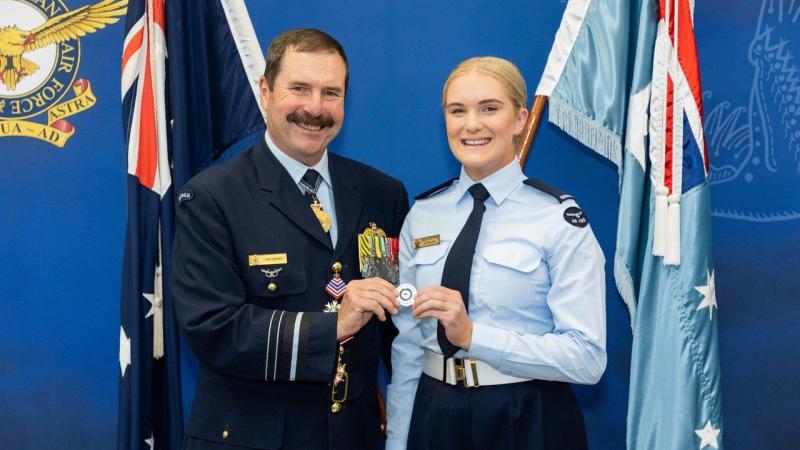 Former chief of Air Force, Air Marshal (retd) Gavin ‘Leo’ Davies, with Aircraftwoman Brooklynn Dowling after her graduation from recruit training, holding the challenge coin the former chief had given to her five years ago. Photo: Cut Above Productions