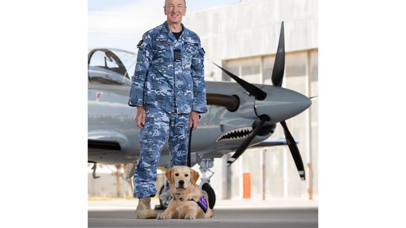 Group Captain Andrew Figtree, Director - Test and Evaluation Directorate with trainee guide dog 'Roman', on the Aircraft Research and Development Unit flight line, at RAAF Base Edinburgh. Photo: Leading Aircraftman Stewart Gould