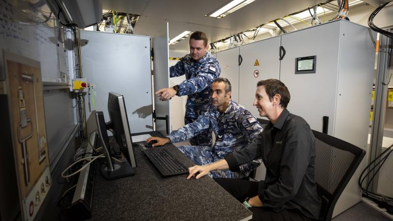 RAAF technicians Corporal Nima Nikfarjam, centre, and Leading Aircraftman Matthew Crowe, left, talk with Hensoldt Australia instructor Prue Bowley about the ASR-NG radar system. Photo: Leading Aircraftwoman Emma Schwenke
