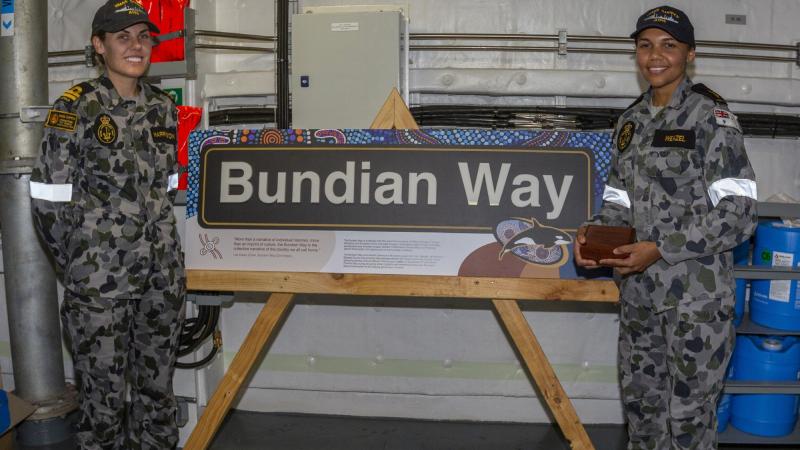 Lieutenant Sarah Harrington, left, and Able Seaman Jahlaya Weazel with the Bundian Way signage in HMAS Supply. Photo: Able Seaman Benjamin Ricketts