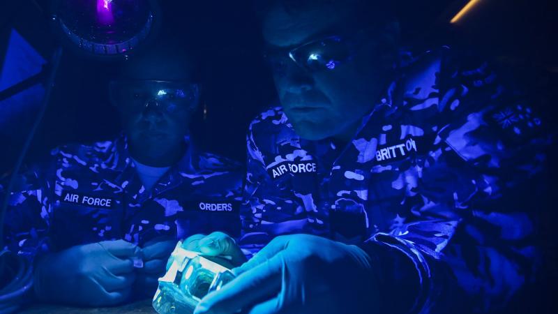 Corporal Daniel Orders (left) and then Sergeant Geoff Britton conduct a fluorescent liquid penetrant test on an aircraft component under ultraviolet light in 2016. Photo: Corporal Brenton Kwaterski
