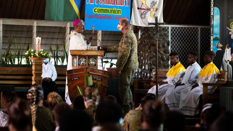 Australian Army padre Chaplain Haydn Parsons is presented a farewell gift by Archbishop Christopher Cardone during a service at Holy Cross Cathedral in Honiara, Solomon Islands. Photo: Corporal Julia Whitwell