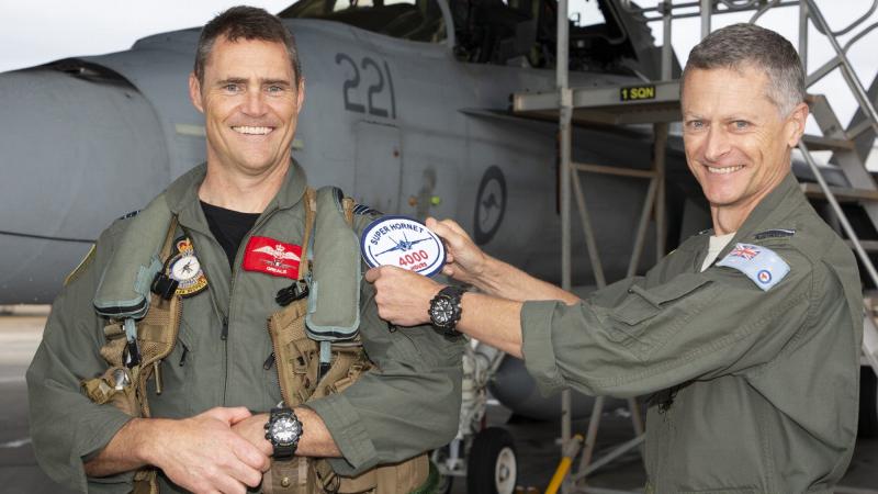 Commander Air Combat Group Air Commodore Timothy Alsop (right) presents Squadron Leader Daniel Grealy with an oversized replica patch on attaining 4000 flying hours in F/A-18 type aircraft at RAAF Base Amberley, Queensland. Photo: Sergeant Peter Borys