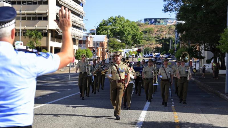 The band of the 1st Battalion, Royal Australian Regiment, led by Lieutenant Colonel Daniel Hiscock, is challenged by a Queensland policeman during the parade in Townsville. Photo: Sergeant James Duquemin