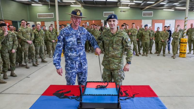 Combat Support Group's Commander, Air Commodore David Paddison, CSC and No. 3 Security Forces Squadron's most junior member, Aircraftman Aidan Tocci, cut the cake to celebrate the squadron's 20th birthday. Photo: Corporal Brenton Kwaterski